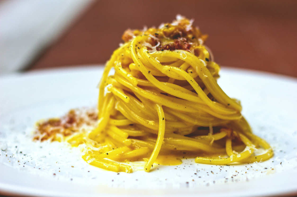 INGREDIENTS:

- 600g of spaghetti
- 250g guanciale
- 6 eggs
- 100g pecorino cheese
- Salt
- Black pepper

RECIPE:

Put the water in a pot and bring it to a boil, then add salt to taste.
Cut the guanciale into strips. Some might say that it is better to cut it into cubes, but the advantage of cutting it into strips is that it will become more crispy and consistent. Brown it in a pan, after having sprinkled with pepper. No oil is needed, the bacon is already fat on its own.
Beat the eggs in a bowl, season with pepper and half the Pecorino cheese (about 50 g), then mix carefully until the mixture is homogeneous and creamy. Remember to add a little bit of the fat of the guanciale during the mixing.
Cook the pasta "al dente", drain it and put it back into the hot pan of the guanciale.
To get the best result you should drain the spaghetti very al dente and add a little bit of cooking water.
Pour the beaten eggs cream into the pan with the pasta and mix it well, until it becomes very creamy.
Pour the contents into the plates, sprinkle with the remaining Pecorino Romano and black pepper.